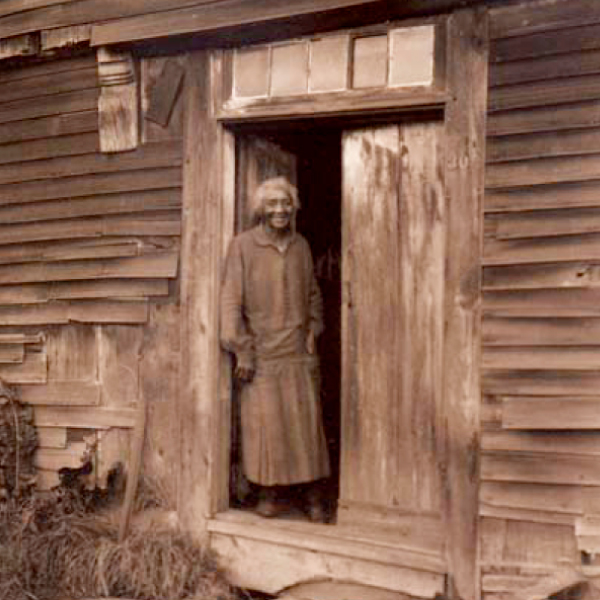 A woman who was a form er slave standing outside her cabin on Cape Ann