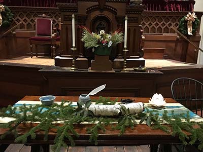 altar decorated with evergreen branches for the Winter Solstice