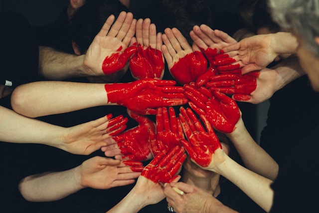 artistic photo of a heart painted over a collection of hands