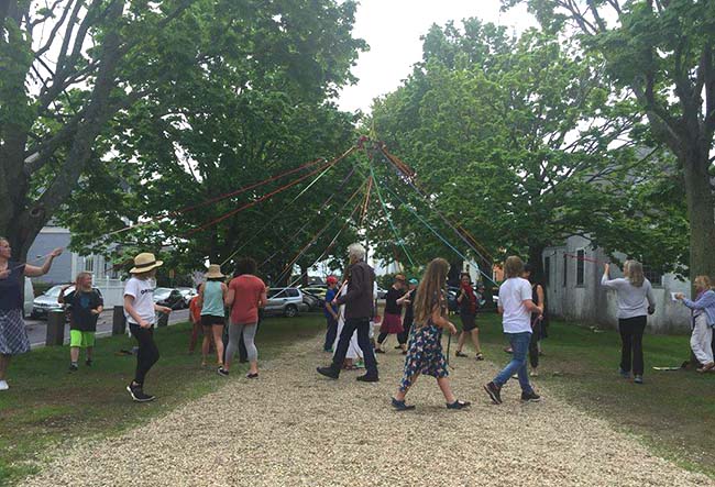 people dancing around a maypole in late spring